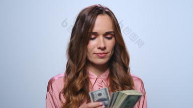 女商人计数钱蓝色的背景女人持有现金工作室